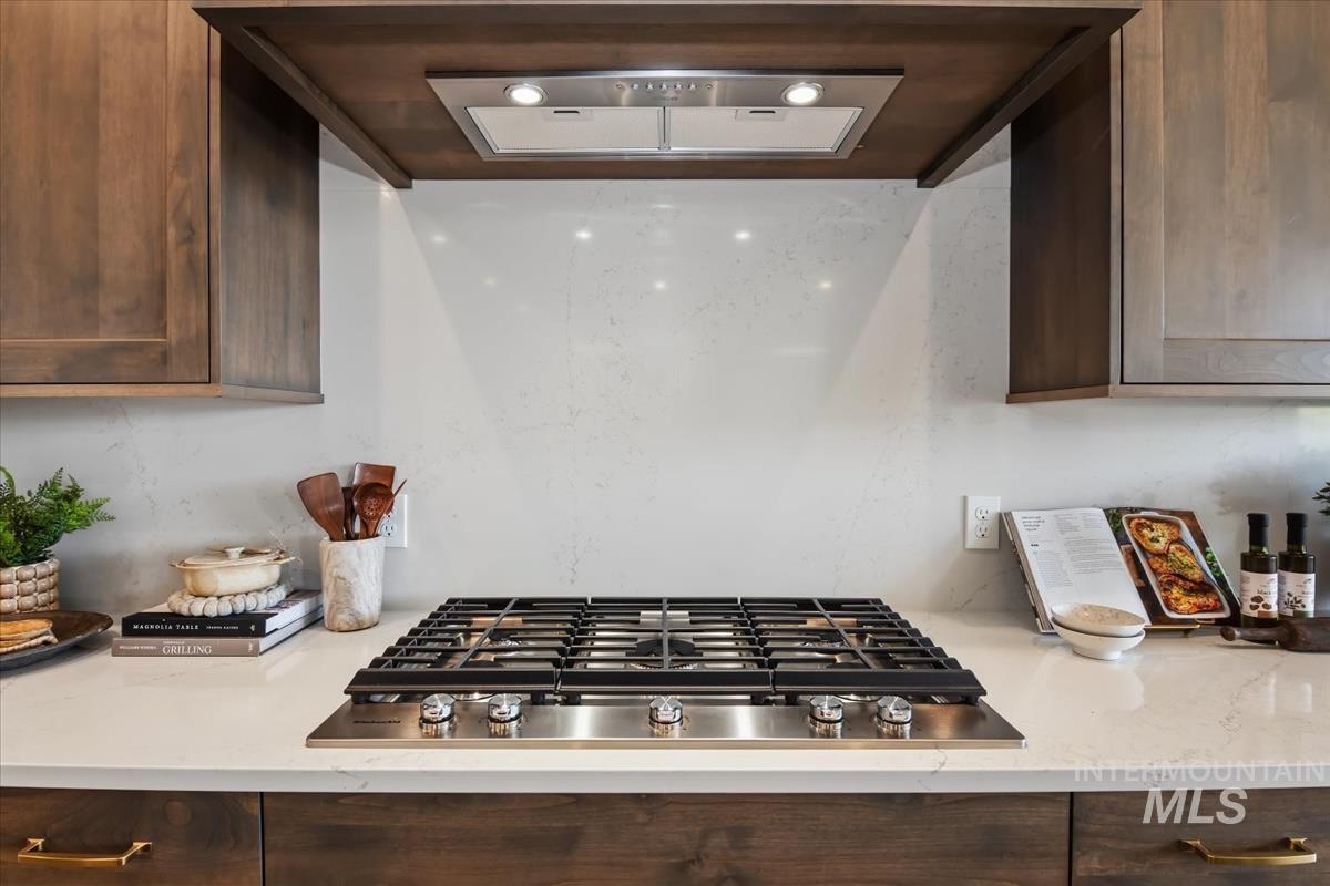 7615 Brown Way Eagle, ID 83714 - Photo 18 of 43 Built-in stainless steel gas cooktop with five burners, complemented by a stainless steel range hood with integrated lighting