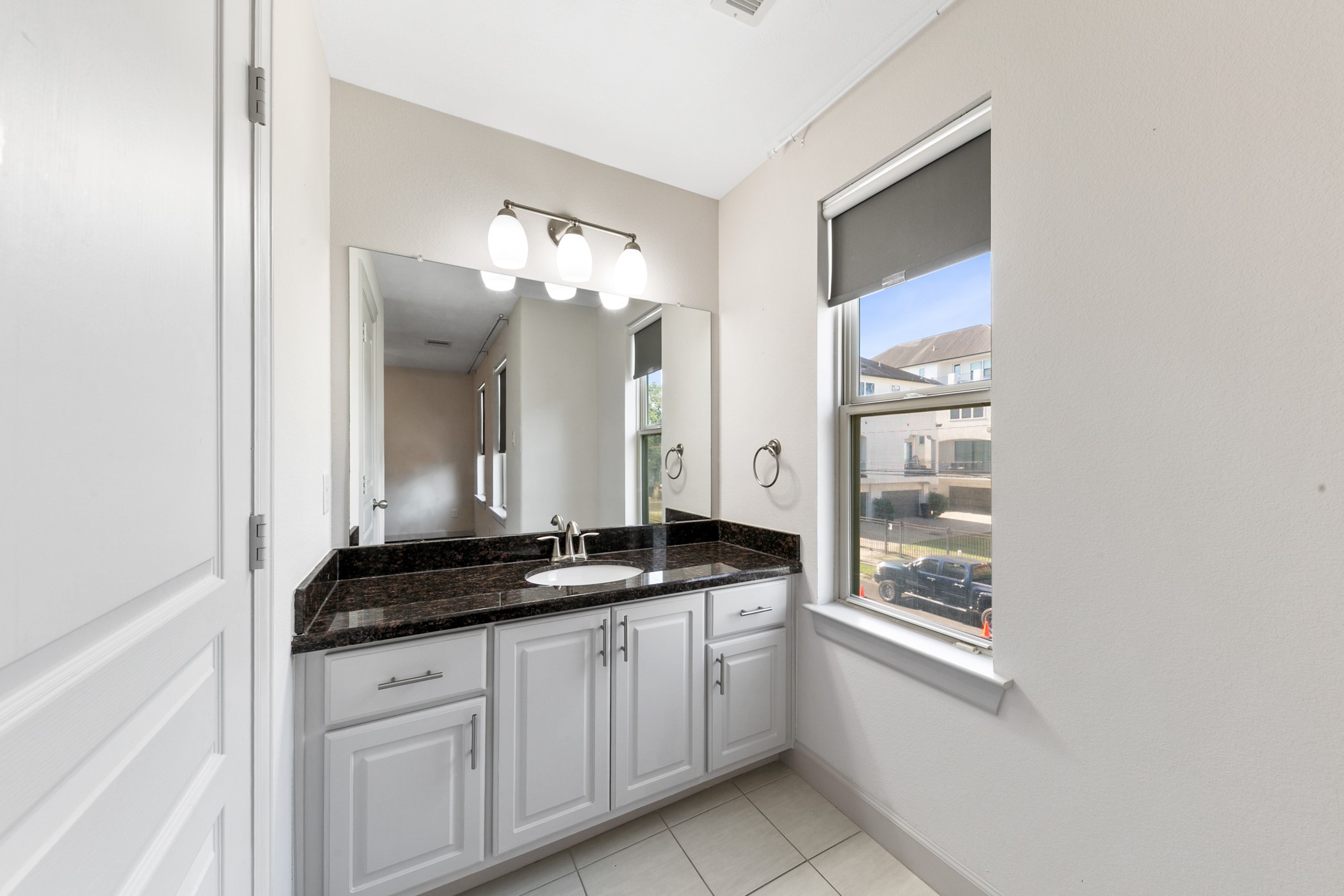 1809 Wichita Street Houston, TX 77004 - Photo 27 of 32 a bathroom with a granite countertop sink and a mirror