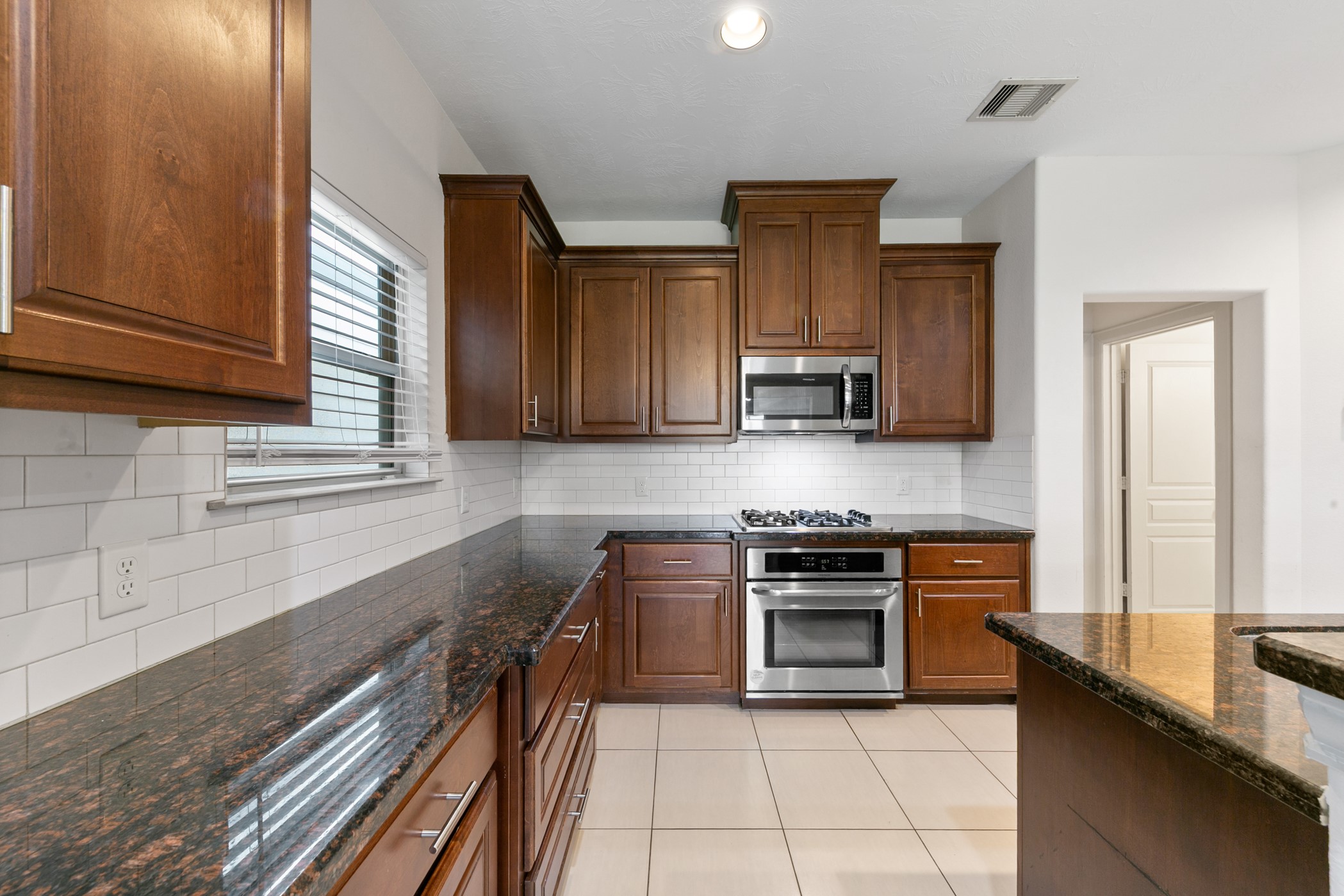 1809 Wichita Street Houston, TX 77004 - Photo 10 of 32 a kitchen with stainless steel appliances granite countertop a stove a sink and a microwave
