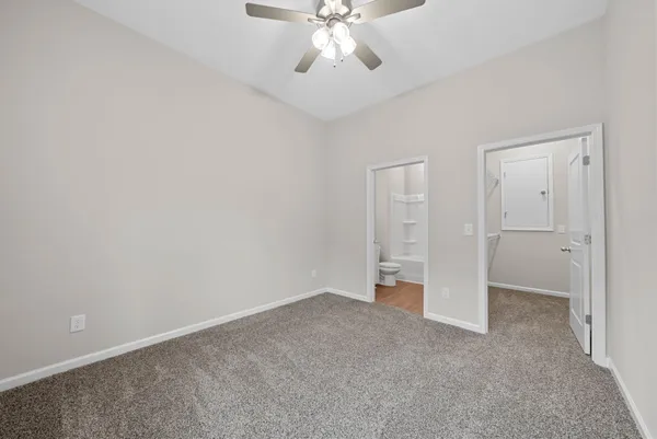 a view of an empty room and chandelier fan