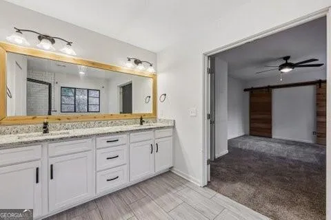 a bathroom with a granite countertop sink vanity and mirror