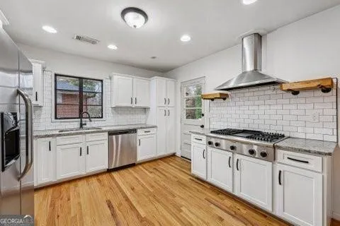 a kitchen with stainless steel appliances granite countertop a stove and white cabinets
