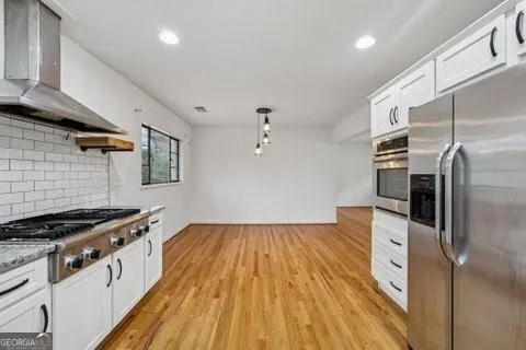 a kitchen with stainless steel appliances granite countertop a stove and a refrigerator