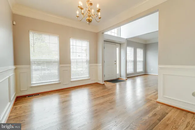 a view of a white house with a big yard and large trees