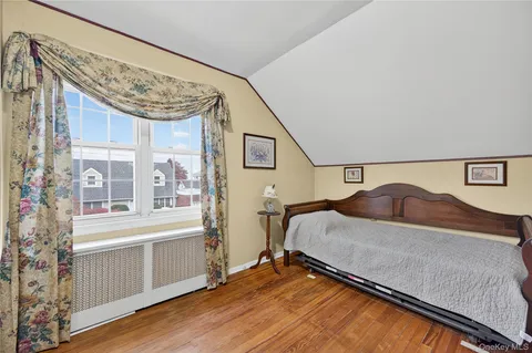 a bedroom with a bed and a large window
