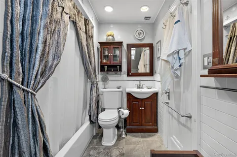a bathroom with a toilet sink and mirror