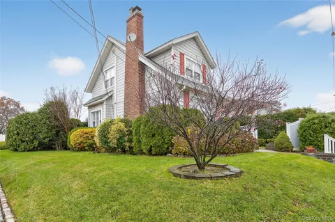 a front view of a house with a yard and trees