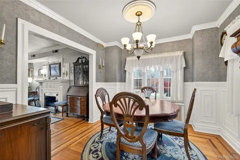 a view of a dining room with furniture a chandelier and wooden floor