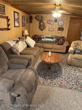 a living room with furniture a large window and a dining table