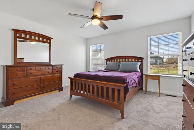 a bedroom with a bed dresser and a flat tv screen