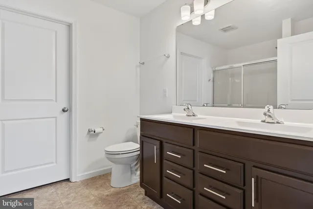 a kitchen with stainless steel appliances kitchen island granite countertop a stove a refrigerator a kitchen island a dining table and chairs with wooden floor