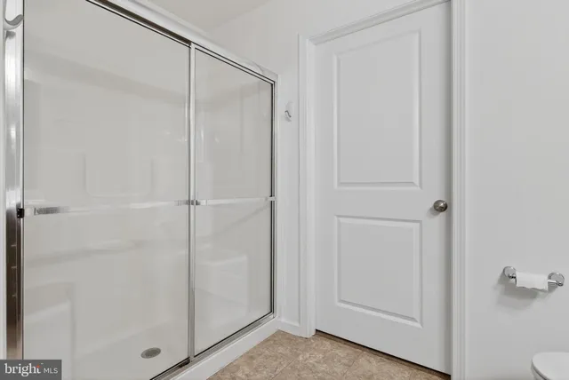 a kitchen with stainless steel appliances granite countertop a sink a stove a refrigerator and white cabinets with wooden floor