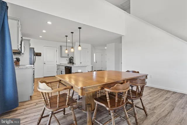 a living room with furniture and a dining table with kitchen view