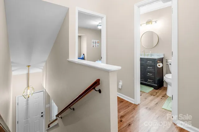 a view of a hallway with entryway wooden floor and cabinet
