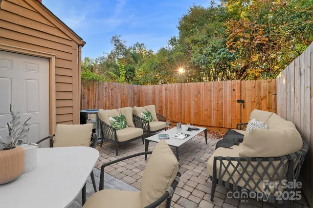 a backyard of a house with dining table and chairs