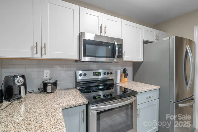 a kitchen with appliances a sink and cabinets
