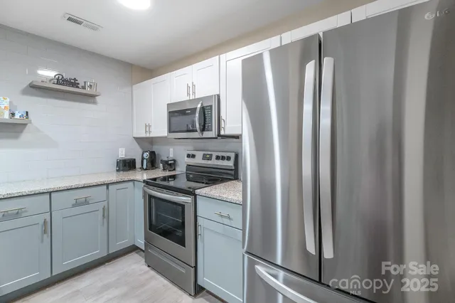 a kitchen with stainless steel appliances a refrigerator sink and microwave