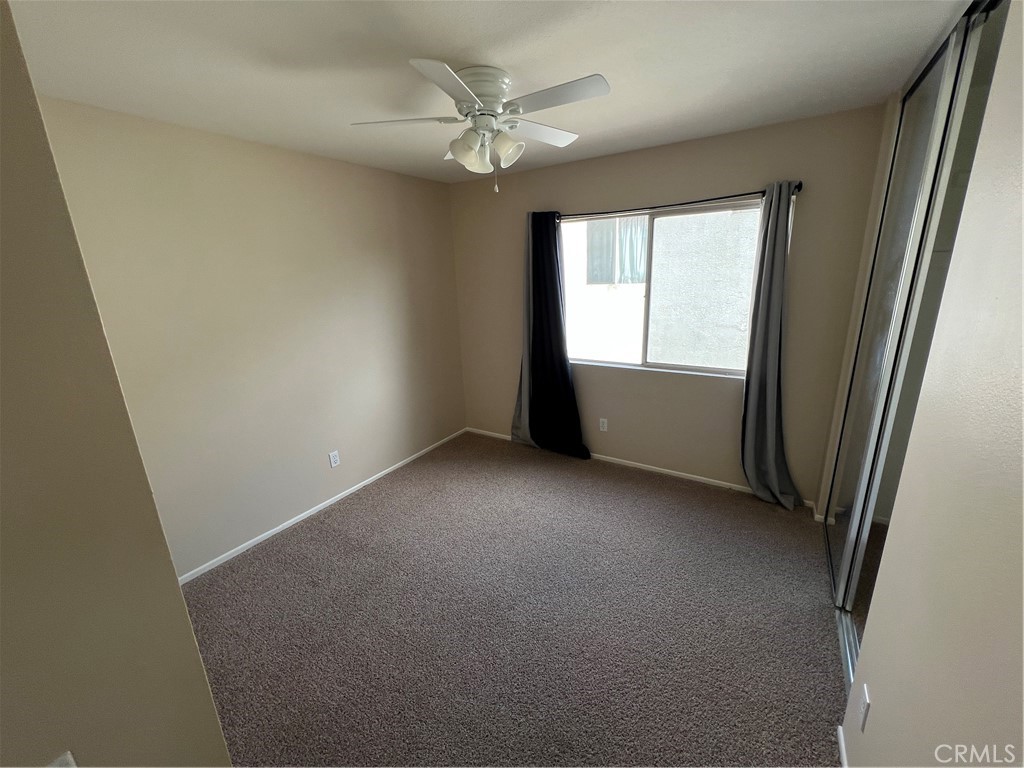 31264 Nice Avenue Mentone, CA 92359 - Photo 20 of 28 an empty room with windows and chandelier fan