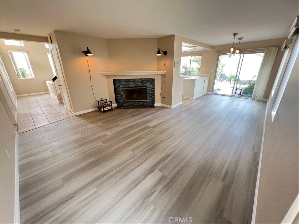 31264 Nice Avenue Mentone, CA 92359 - Photo 3 of 28 an empty room with wooden floor fireplace and windows