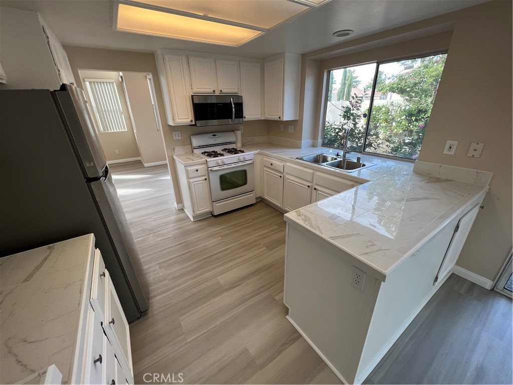 31264 Nice Avenue Mentone, CA 92359 - Photo 5 of 28 a kitchen with a stove a sink and a microwave