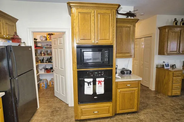 a kitchen with stainless steel appliances granite countertop a refrigerator and a stove top oven