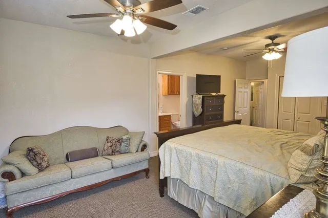 a spacious bedroom with a bed and ceiling fan