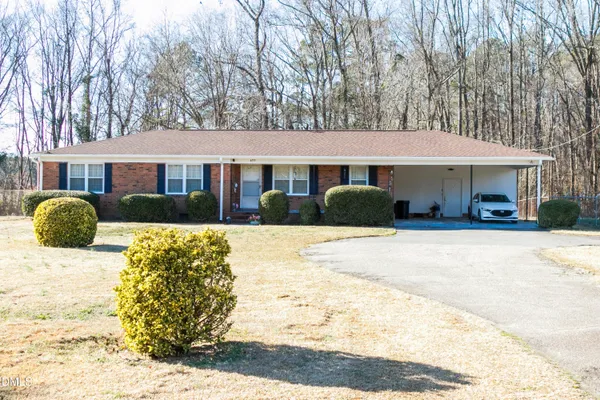 a front view of a house with a yard covered in snow