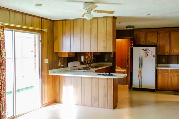 a kitchen with stainless steel appliances granite countertop a refrigerator a stove and a sink with cabinets