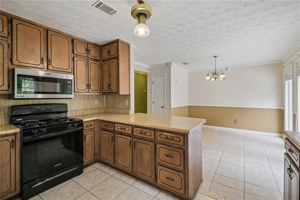 1318 Panhandle Way Hampton, GA 30228 - Photo 5 of 22 a kitchen with stainless steel appliances a stove a microwave and sink