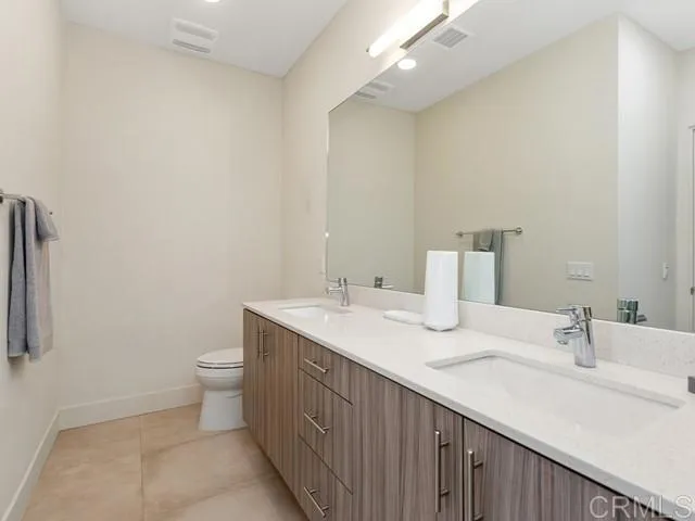 a bathroom with a sink a toilet and a mirror