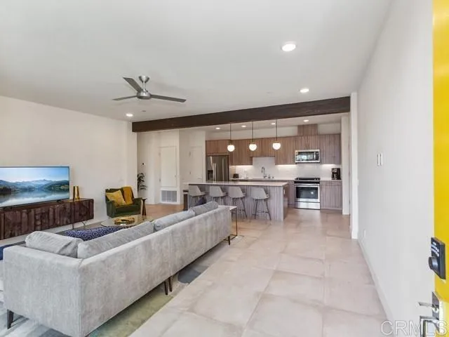 a living room with couches and kitchen view