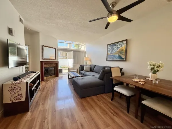 a living room with furniture a flat screen tv and a wall paintings