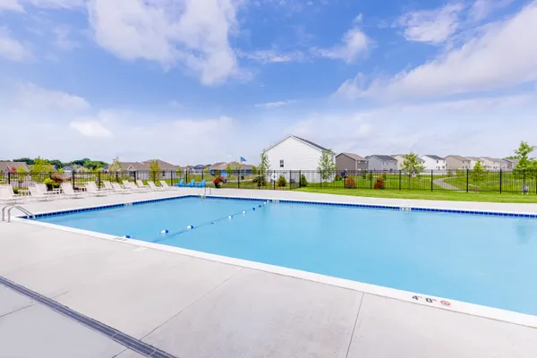 a swimming pool with outdoor seating and yard in back
