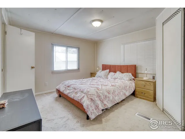a large bed sitting in a bedroom next to a window