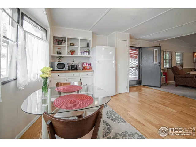 a kitchen with stainless steel appliances kitchen island granite countertop a refrigerator a stove a sink dishwasher with a dining table and chairs with wooden floor