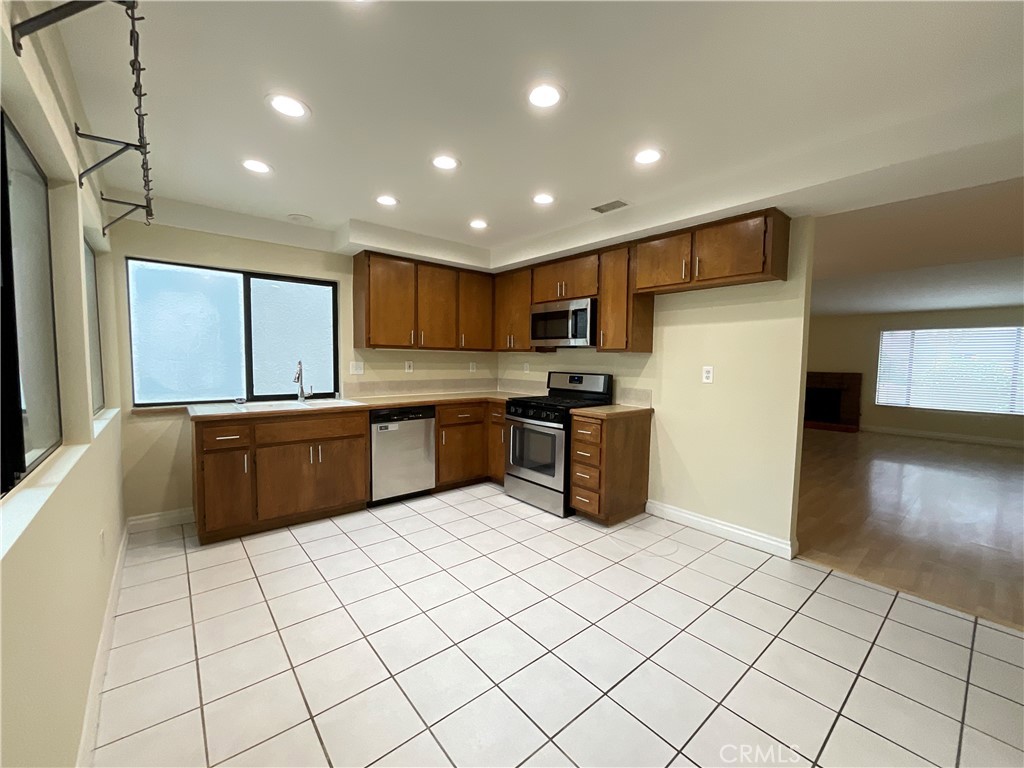7053 Seawind Drive Long Beach, CA 90803 - Photo 11 of 47 a kitchen with stainless steel appliances a sink counter space and cabinets