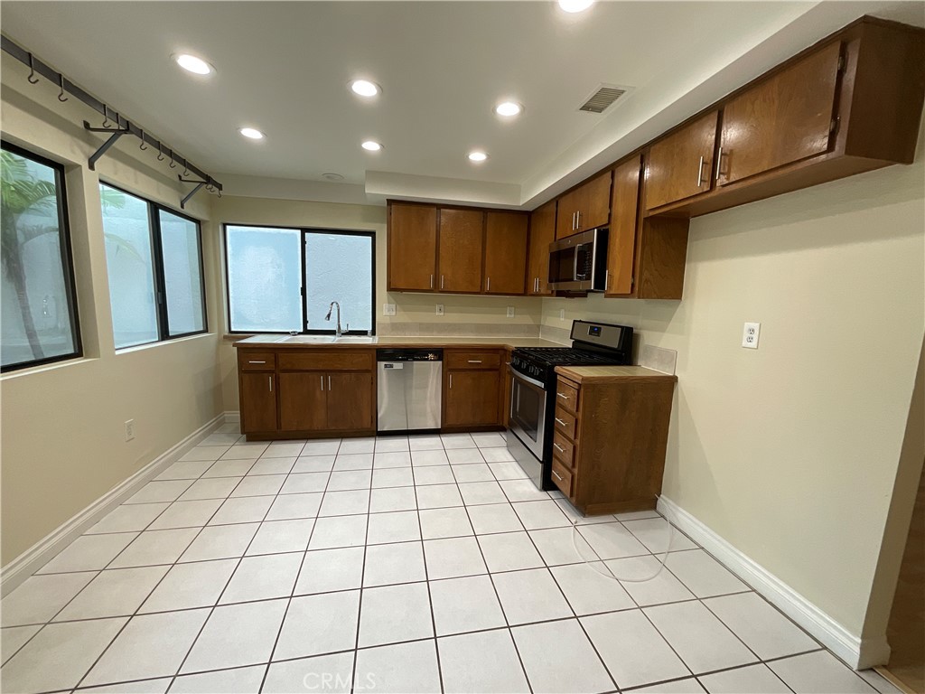 7053 Seawind Drive Long Beach, CA 90803 - Photo 13 of 47 a kitchen with stainless steel appliances a sink a stove a microwave a counter top space and cabinets