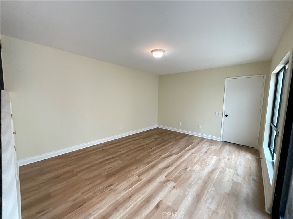 7053 Seawind Drive Long Beach, CA 90803 - Photo 17 of 47 an empty room with wooden floor and window