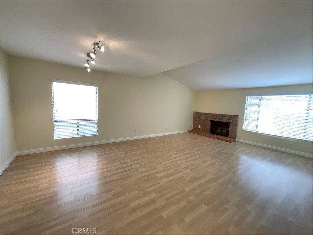 7053 Seawind Drive Long Beach, CA 90803 - Photo 3 of 47 an empty room with wooden floor fireplace and windows