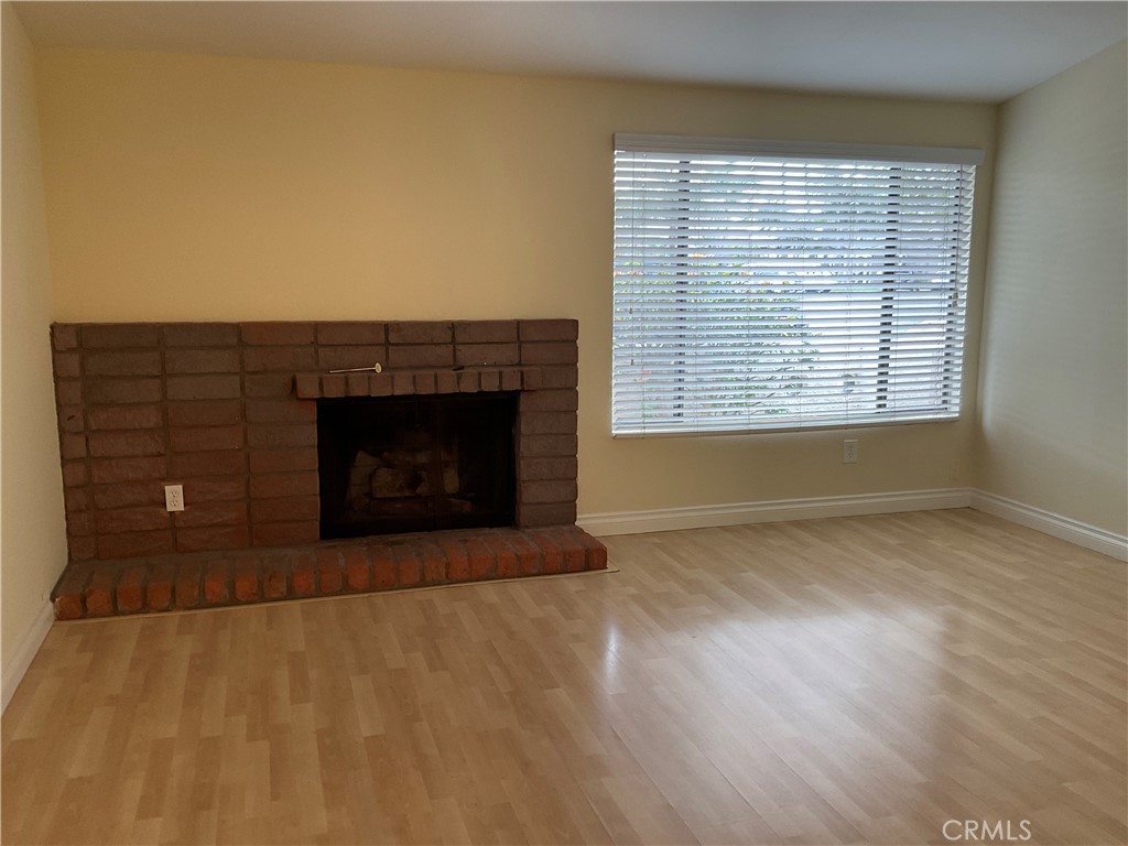7053 Seawind Drive Long Beach, CA 90803 - Photo 8 of 47 a view of an empty room with wooden floor fireplace and a window