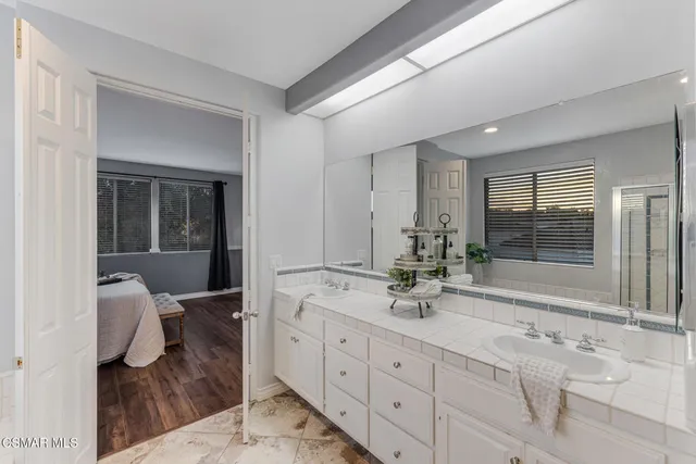 a bathroom with a tub sink and mirror