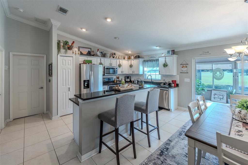 15143 Southwest 14th Avenue Road Ocala, FL 34473 - Photo 10 of 53 a kitchen with stainless steel appliances a dining table chairs and a refrigerator