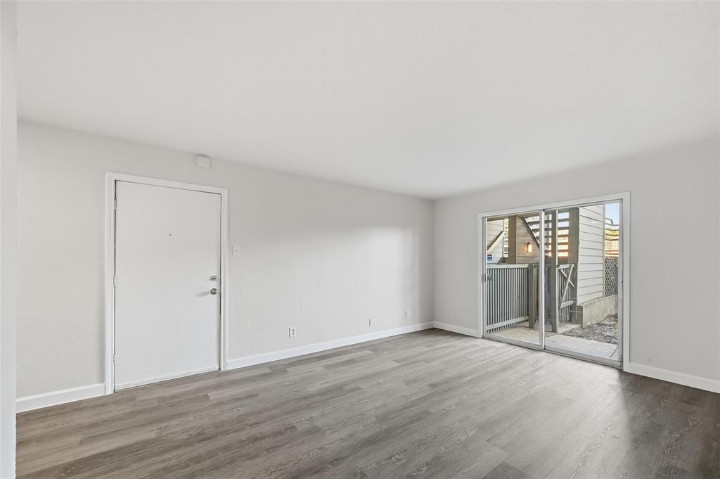 4859 Cedar Springs Road, Unit 136 Dallas, TX 75219 - Photo 14 of 28 an empty room with wooden floor and windows