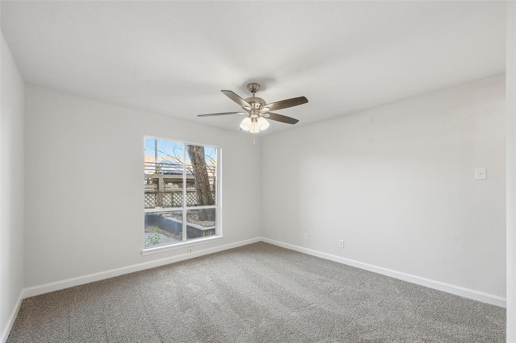 4859 Cedar Springs Road, Unit 136 Dallas, TX 75219 - Photo 20 of 28 an empty room with windows and fan