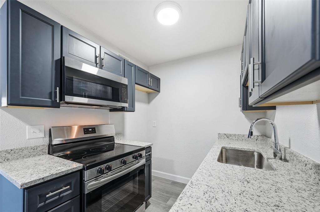 4859 Cedar Springs Road, Unit 136 Dallas, TX 75219 - Photo 8 of 28 a kitchen with stainless steel appliances granite countertop a sink stove and microwave