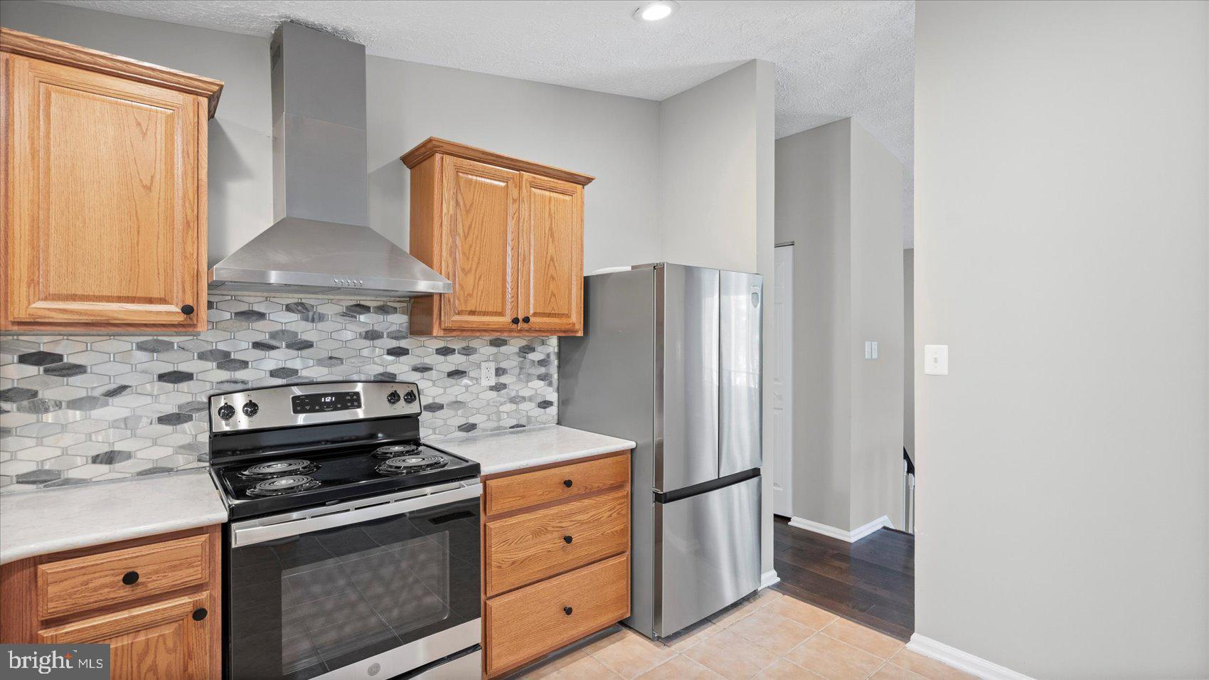 3709 Redberry Way Nottingham, MD 21236 - Photo 15 of 45 a kitchen with stainless steel appliances a stove a refrigerator and cabinets