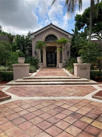 a front view of a house with garden and trees