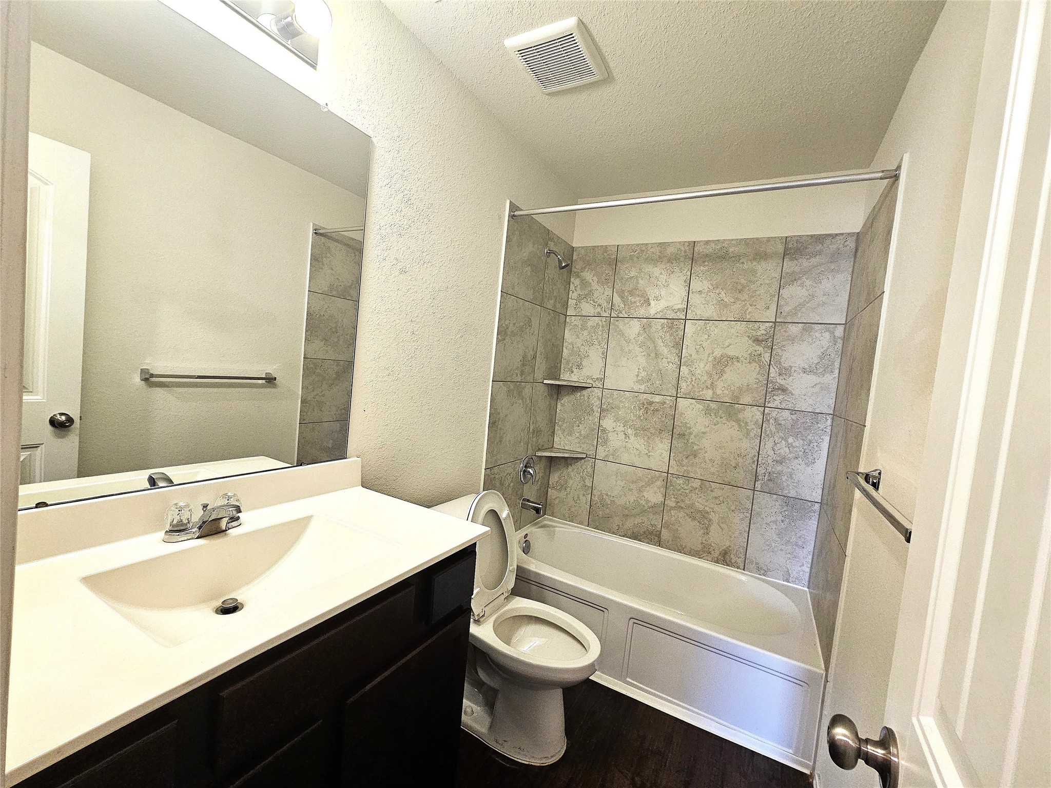 17439 Chester Valley Trail Hockley, TX 77447 - Photo 15 of 22 This bathroom features a modern design with a tiled shower-tub combo, a sleek vanity with a wide mirror, and neutral walls.