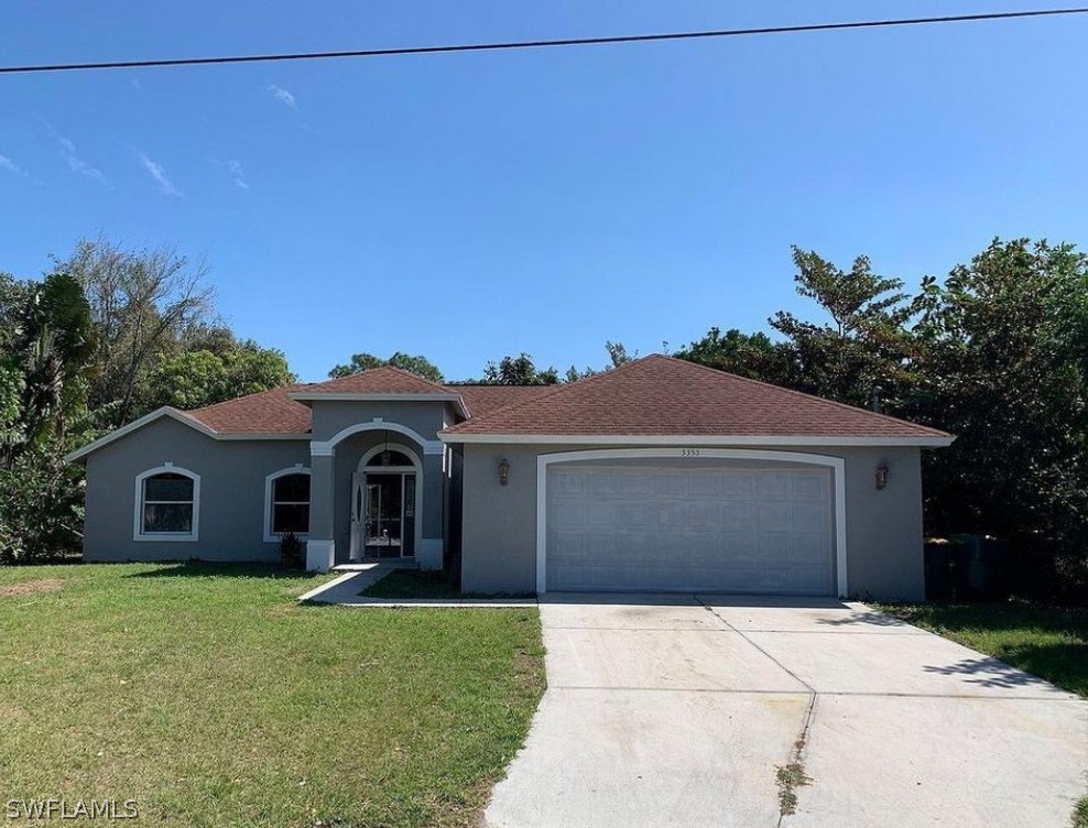 3353 Captains Cove Naples, FL 34112 - Photo 1 of 13 a front view of a house with a garden and yard