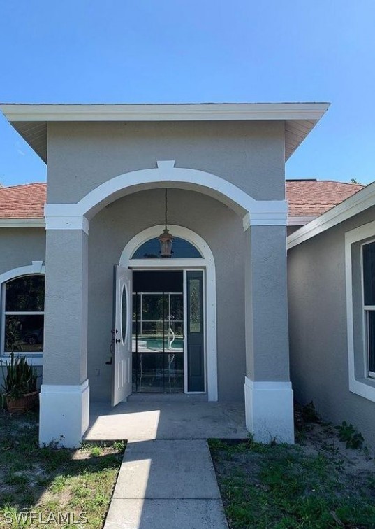 3353 Captains Cove Naples, FL 34112 - Photo 2 of 13 a front view of a house with garden